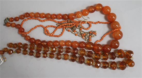 An amber necklace, two coral necklaces, a coral bracelet and one other necklace.